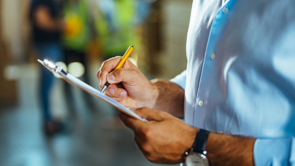 businessman writing on a clipboard