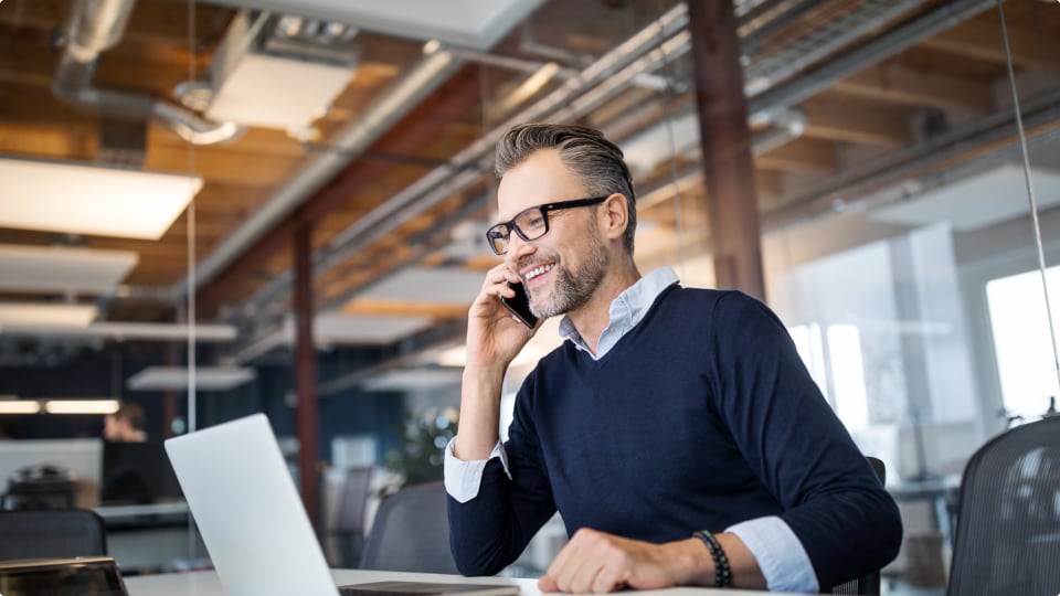 Man on phone confirming shipment details using UPS software