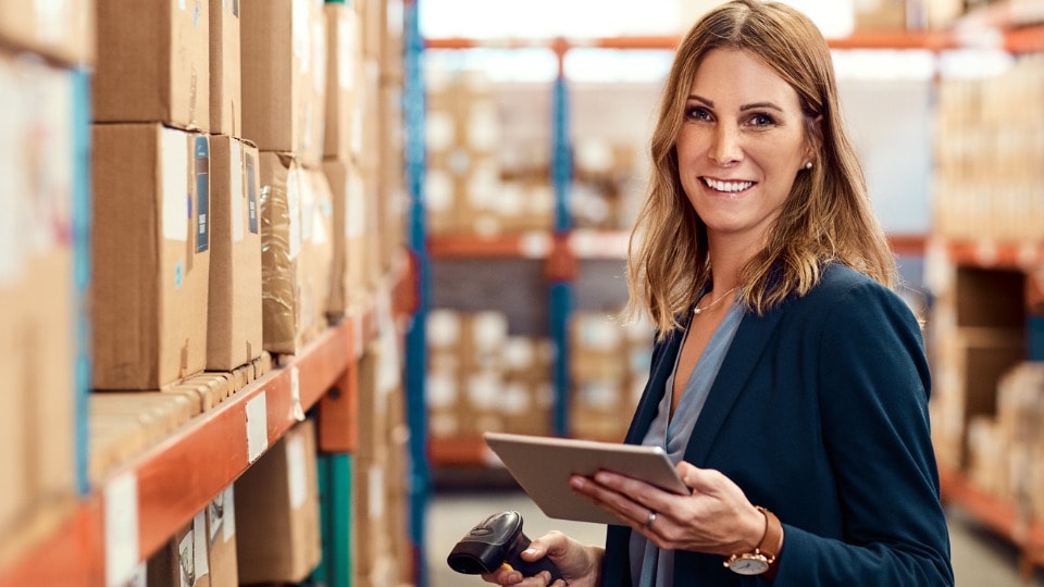 factory manager using a barcode reader and digital tablet in a warehouse