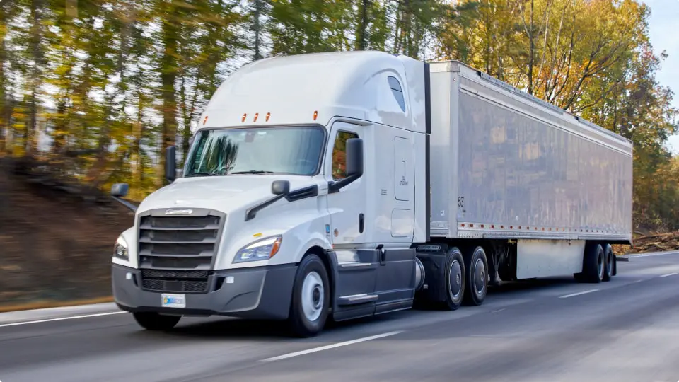 white semi truck driving on the road