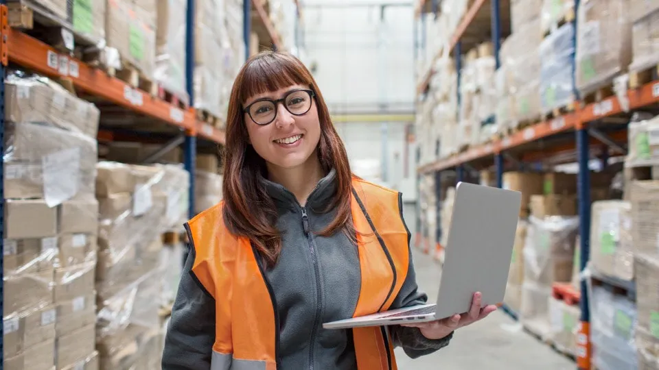 Female worker in the warehouse with a laptop