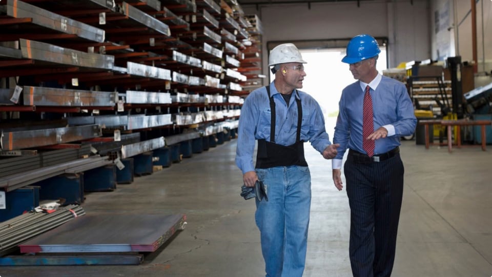 Men in hard hats walking through warehouse