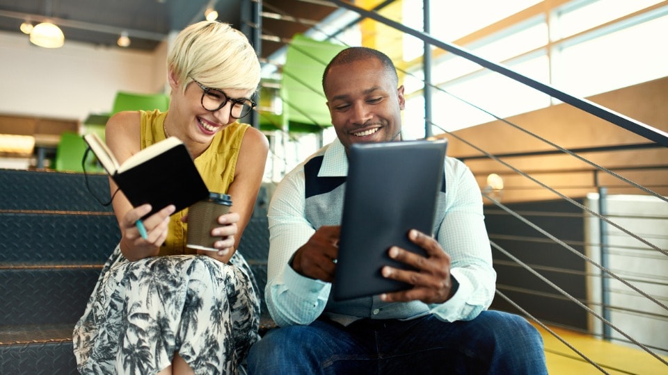 Two business professionals working on a tablet