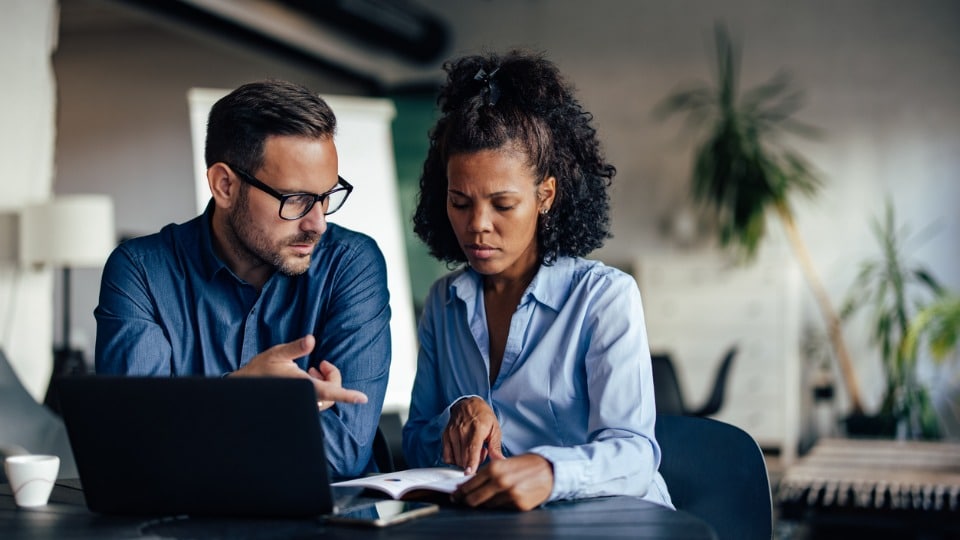 Two businesspeople searching for answers on computer